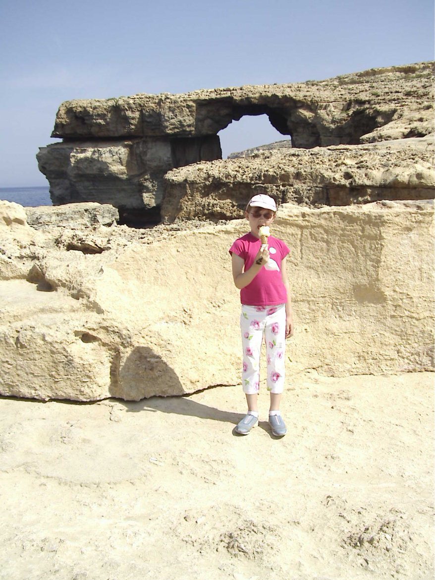 An image in Malta of a little girl standing in front of the Azure window- a guide to visiting Malta.