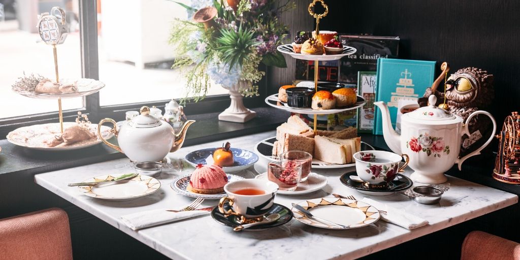 Afternoon tea - table set with cakes and teacups