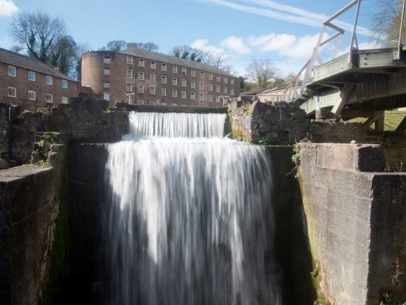 A waterfall with a mill in the background