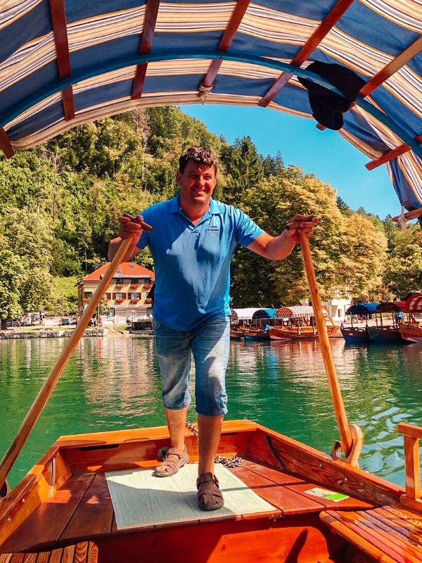 A man rowing a pletna across Lake Bled one of the popular things to do at Lake Bled.