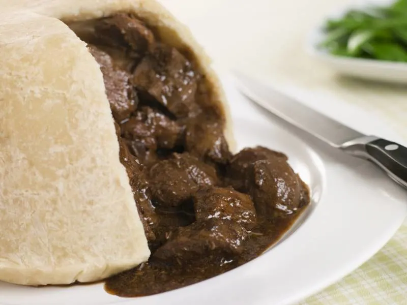 Steak and Kidney Pie with a knife on a plate