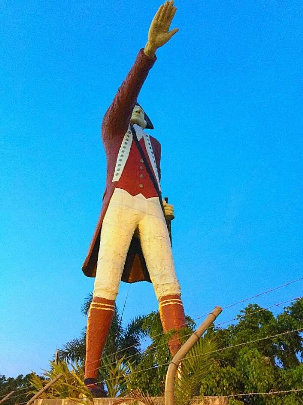 A statue of James Cook with his arm raised