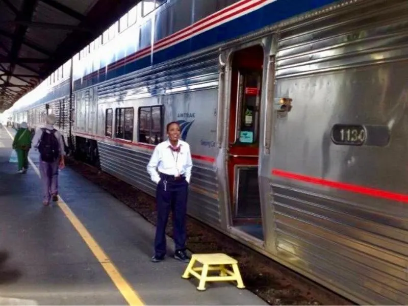 Lady standing outside the Coast Starlight train at Seattle train station.