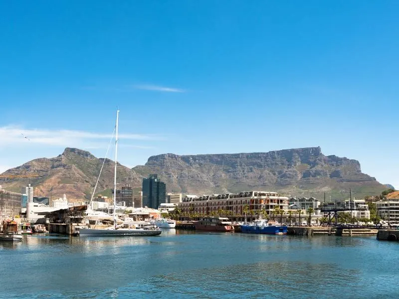 A view of Table Mountain and Cape Town's V&A waterfront with boats.