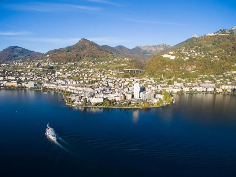 An aerial shot of Montreux on Lake Geneva with a boat crossing the lake