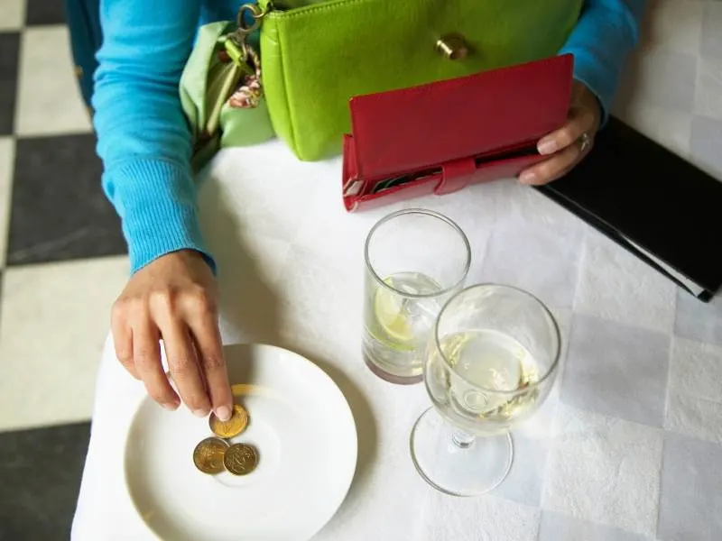 A person leaving a tip on a plate