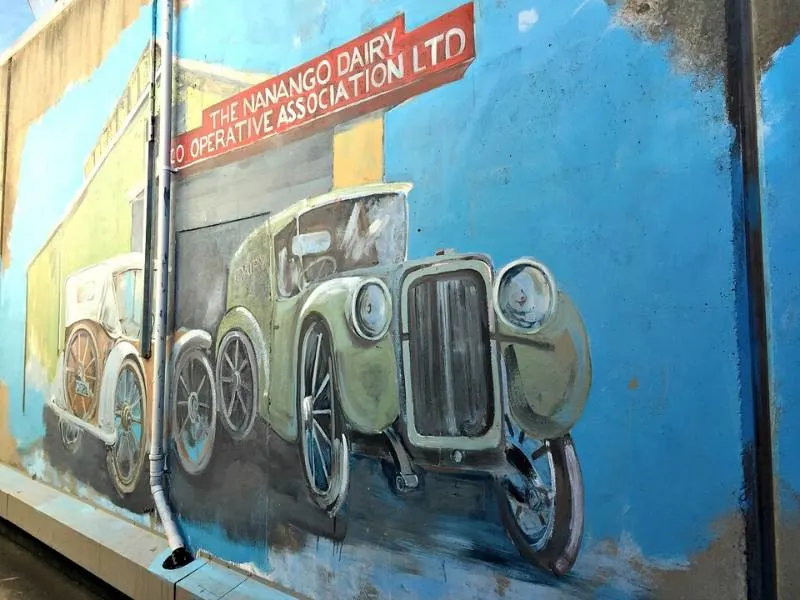 Mural on the wal in Nanango of an old car and a sign for the Nanango Dairy