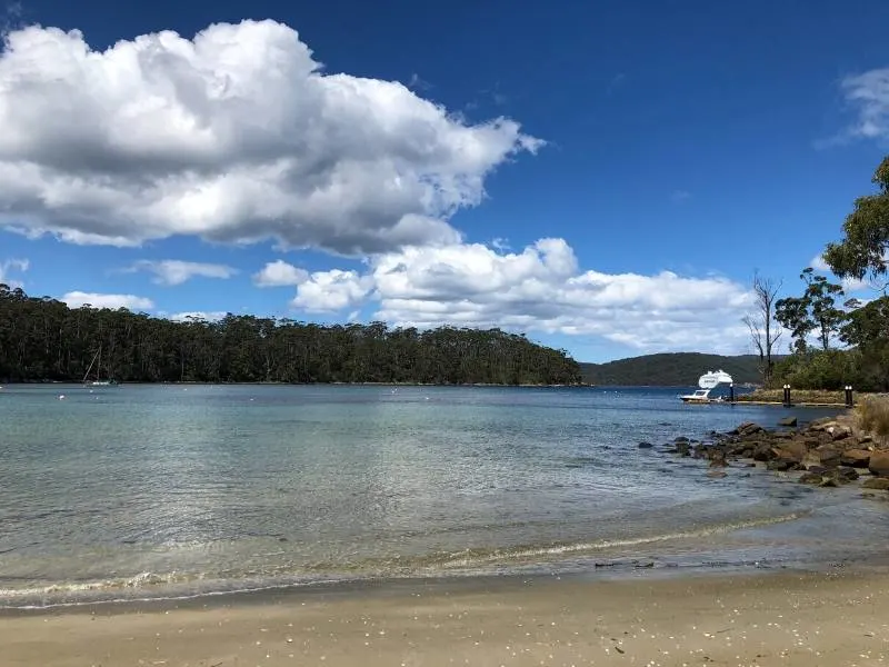 View of a boat from a beach in Tasmania 