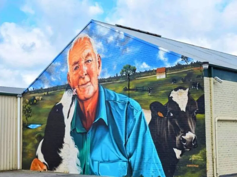 Street art of a farmer and his dog and cows in Yarram Australia an example of Australian street art