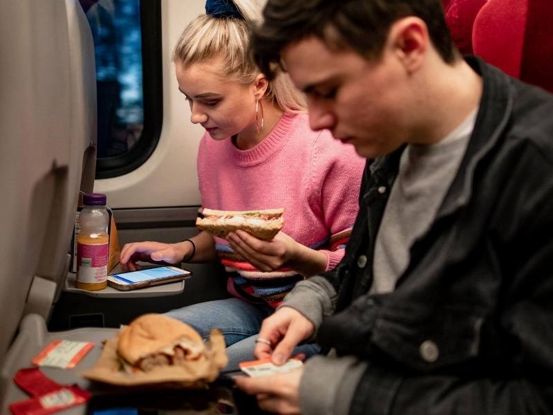 A couple enjoying s meal on a train just one of the advantages of train travel 