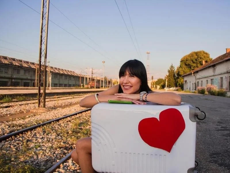 Waiting at a train station with a suitcase