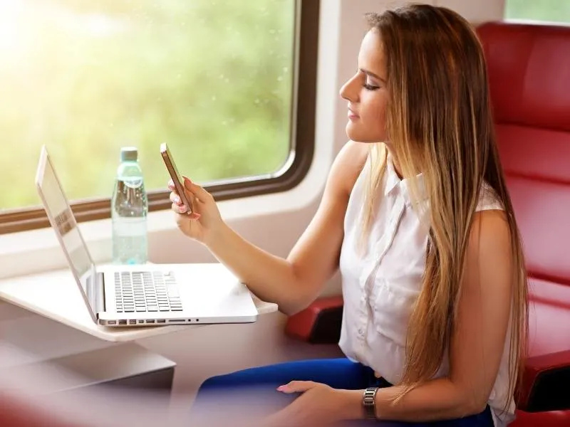 A woman using a mobile phone just one of the advantages of train travel 