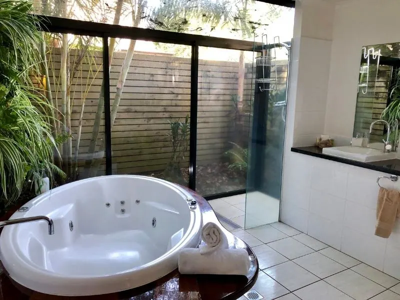 Bathroom with large bath at Witches Falls Cottages.