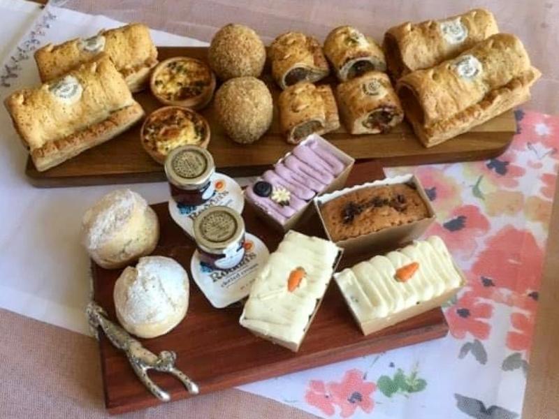 Piglet's Pantry afternoon tea in a box laid out on wooden plates.