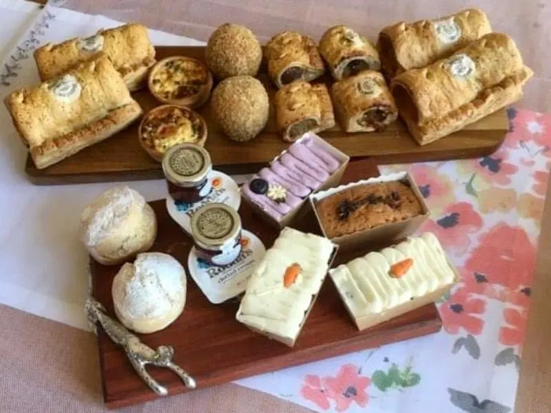 Piglet's Pantry afternoon tea in a box laid out on wooden plates.