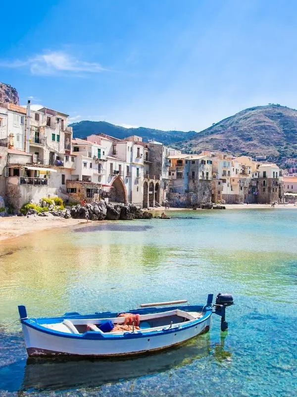 A boat on the sea near a town in Sicily as seen on some Italian TV series on Netflix