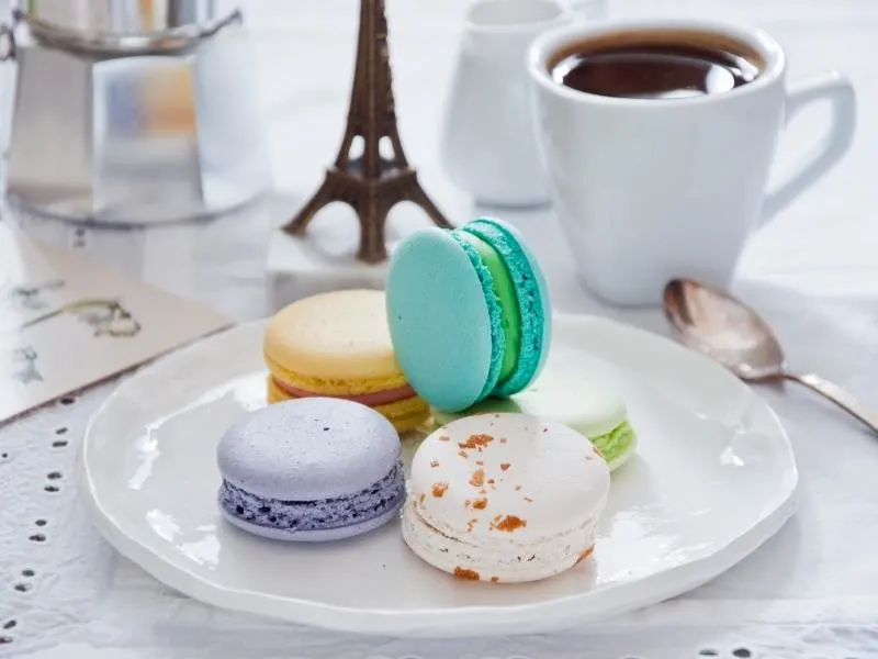 Macarons and a cup of coffee on a table.