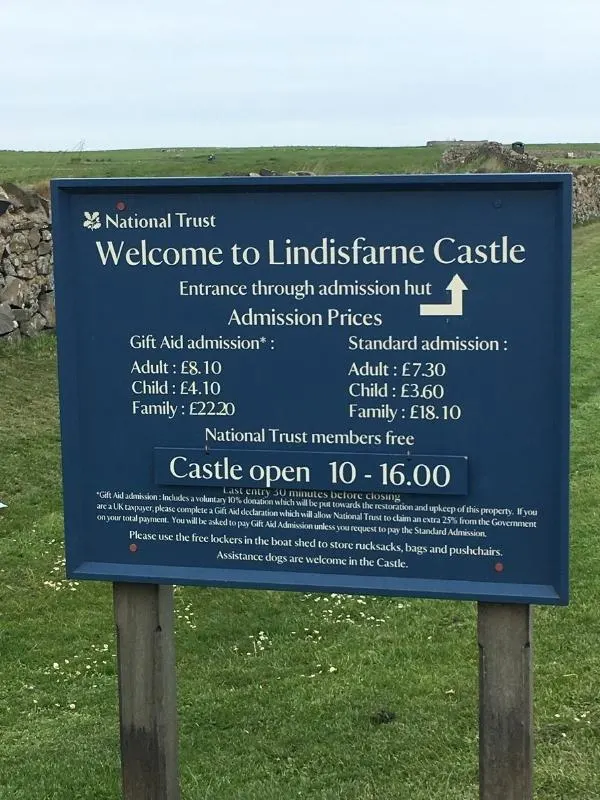 Welcome board for Lindisfarne Castle with prices - a visit is one of the best things to do on Holy Island.