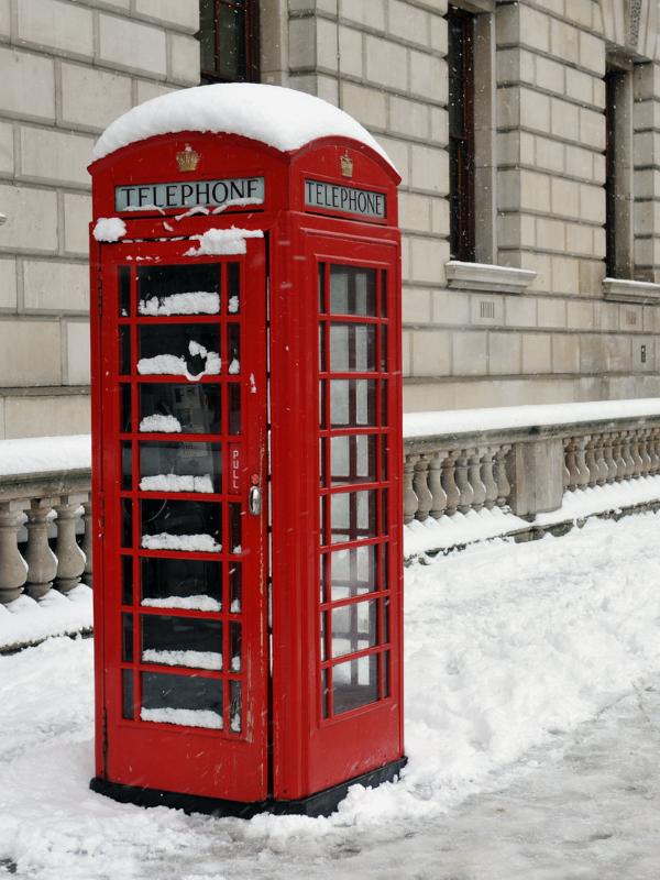 Red London phone box in the snow.