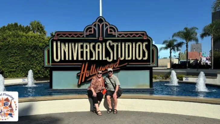 Man and woman beneath a sign for Universal Studios LA