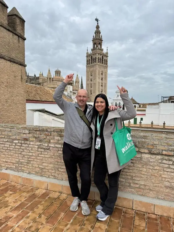 a man and a woman pointing at a building behind them