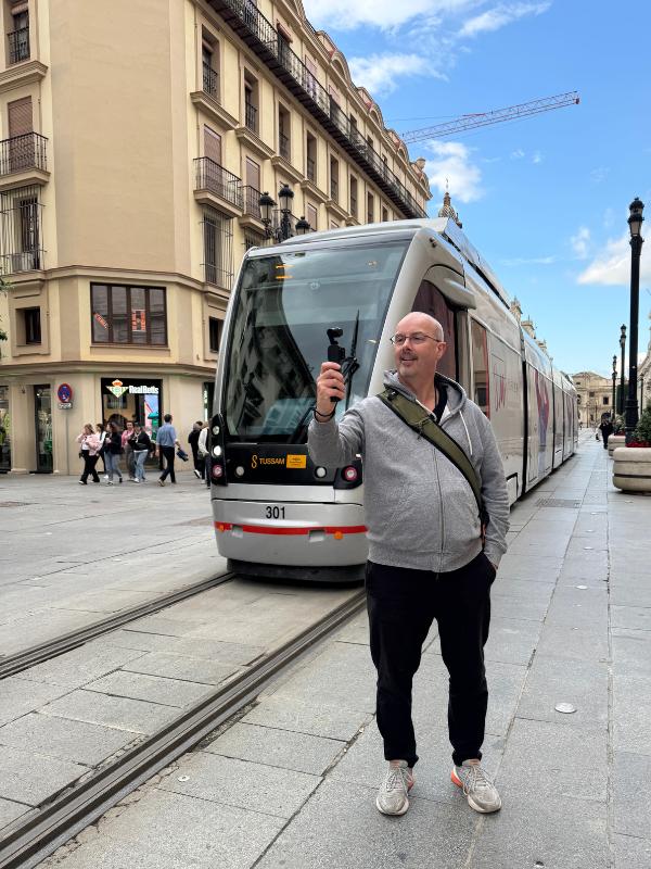 man standing in front of a tram.