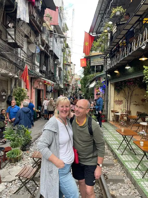 Tracy and Doug Collins who share Vietnam Travel Tips standing on train street in Hanoi Vietnam.