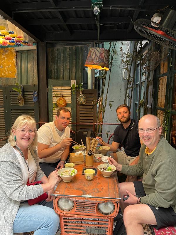 Four people at a table with food.