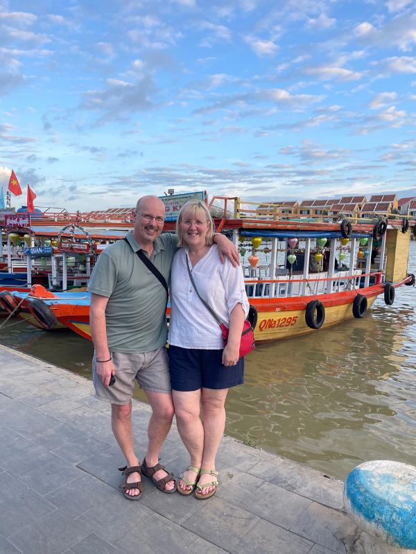 Couple standing in front of a boat.